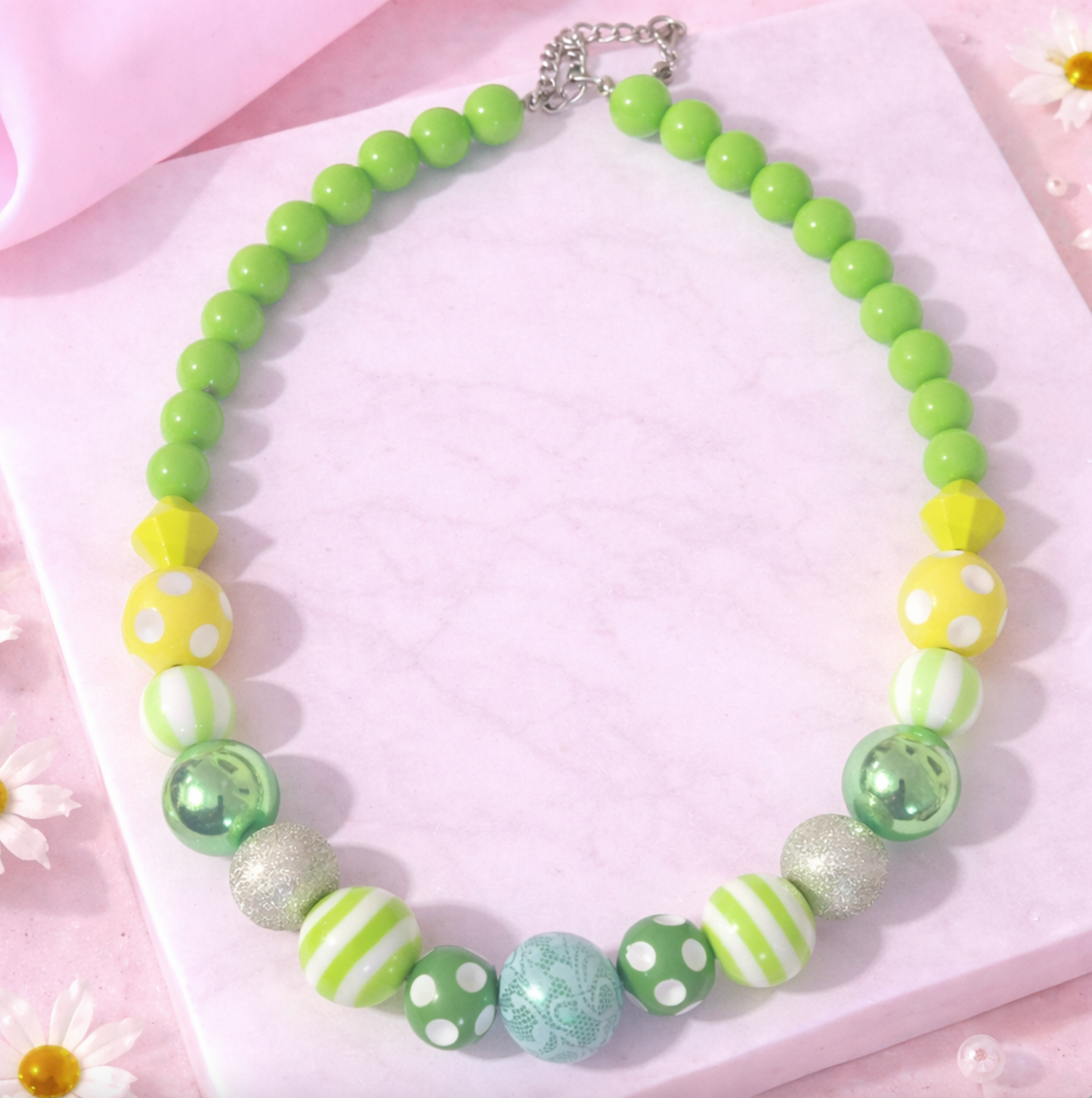 Green and Lime green statement beaded necklace with mixed bead sizes on pink marble background
