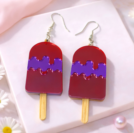 Red and purple popsicle-shaped acrylic earrings with silver hooks on a soft neutral background