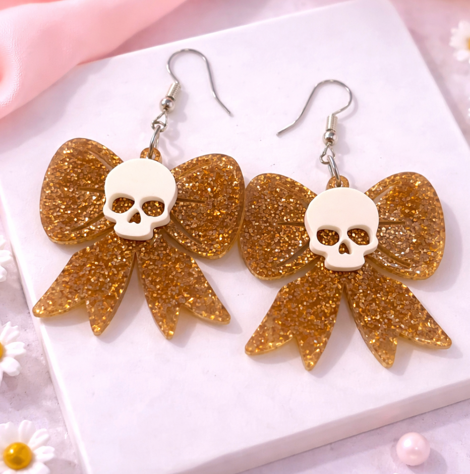 Gold glitter skull bow drop earrings with white skull centre, retro gothic acrylic earrings